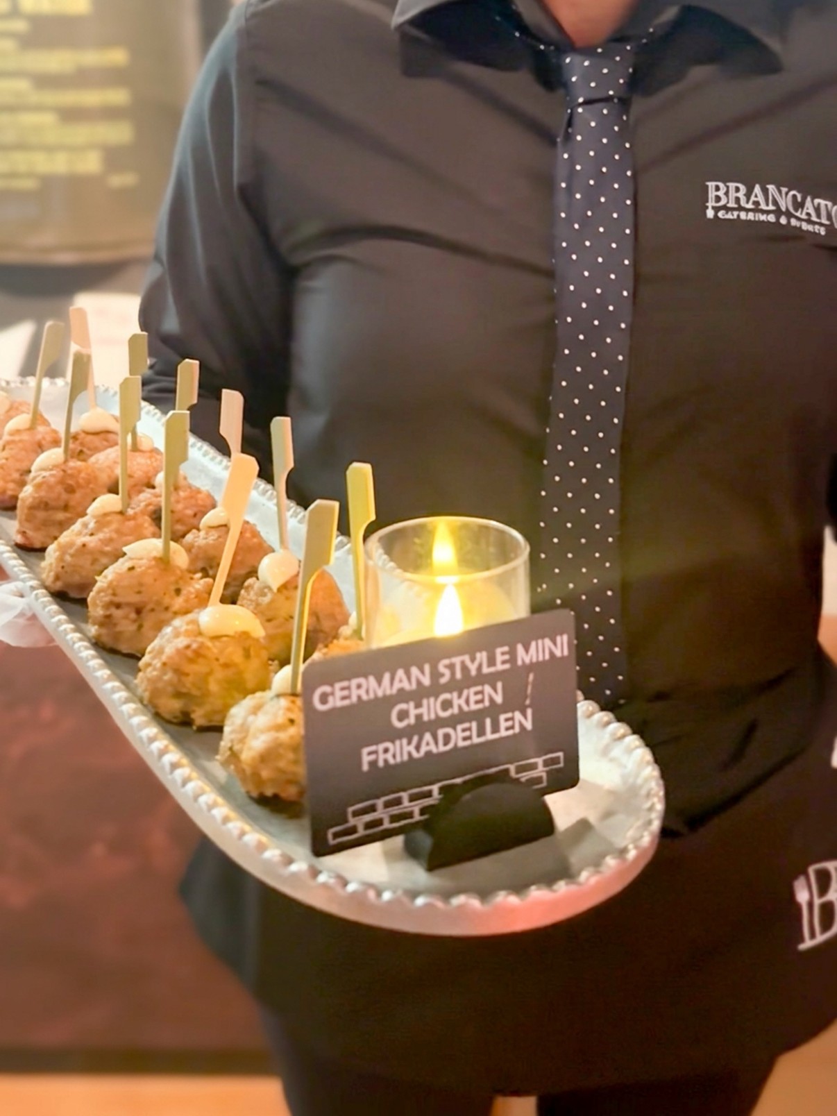 Platte mit Appetithäppchen, präsentiert mit einem personalisierten Lebensmitteletikett, erstellt mit Edikio Guest Flex.